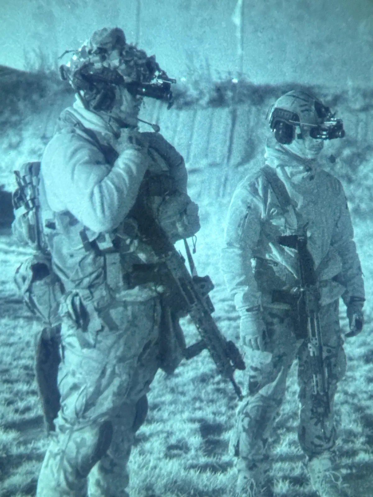 Shooters in winter gear with night-vision goggles and rifles seen through NODs at Poland Shooting Center